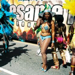 Woman in turquoise carnival costume dancing at parade