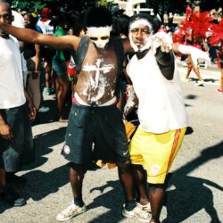 Two men with painted faces dancing at parade