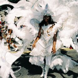 Carnival performer in ornate white feathered costume