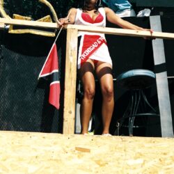 Woman in red bikini and sash on balcony