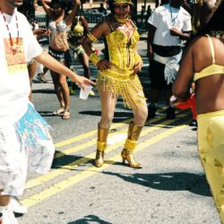 Woman in yellow costume dancing at street carnival