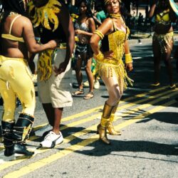Group in yellow carnival costumes dancing on street