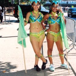 Two carnival dancers in blue-green feathered costumes