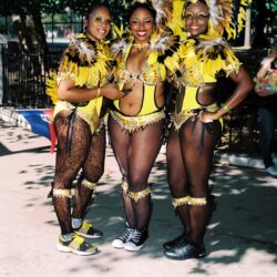 Three women in yellow feathered carnival costumes