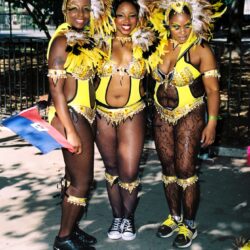Three women in yellow feathered carnival costumes