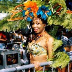 Smiling woman wearing large feathered carnival headdress