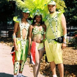Three people in bright green carnival costumes