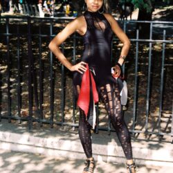 Woman posing outdoors in ripped black outfit