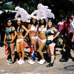Women in feathered carnival costumes at parade