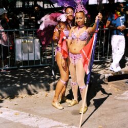 Two women in purple feathered carnival costumes