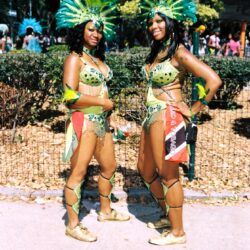 Two women wearing green feathered carnival costumes