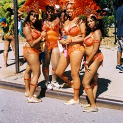 Group of people in orange feathered carnival costumes