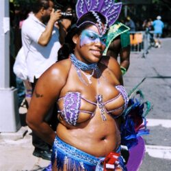 Smiling woman in purple feathered carnival costume
