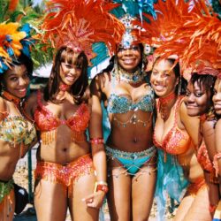 Six women in colorful feathered carnival costumes