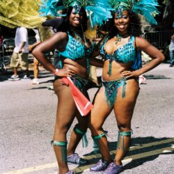 Two performers in teal feathered carnival costumes