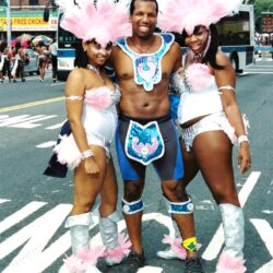Three carnival performers in pink feathered costumes
