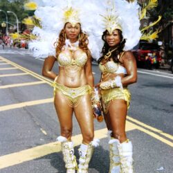 Two carnival dancers in gold feathered costumes