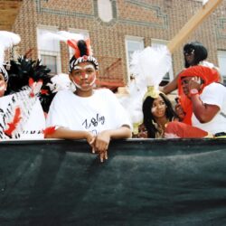 Children in feathered costumes on parade float