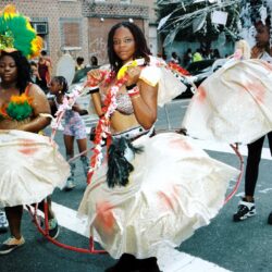 Street carnival dancers wearing colorful feathered costumes