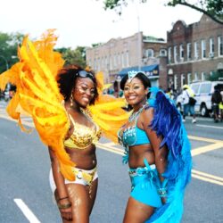 Two women in bright feathered carnival costumes