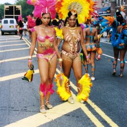 Two women in vibrant carnival costumes walking
