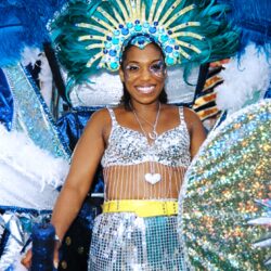 Smiling carnival dancer in blue feathered headdress
