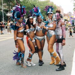 Five carnival dancers posing on city street