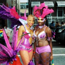 Two women in pink and purple carnival costumes