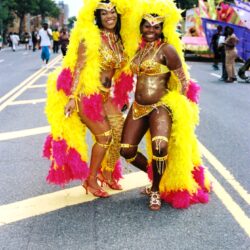 Two women in yellow and pink carnival costumes