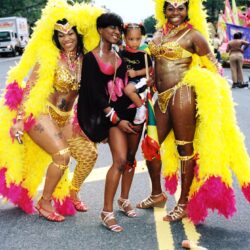 Carnival dancers posing with woman and child