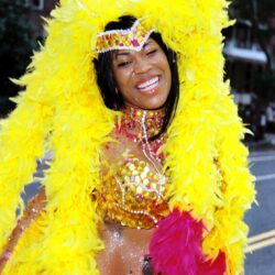 Smiling carnival dancer in yellow feathered costume