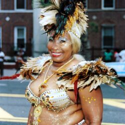 Smiling woman wearing feathered carnival costume