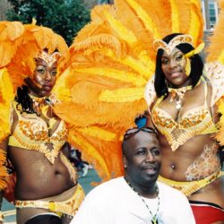 Two performers in elaborate orange carnival costumes
