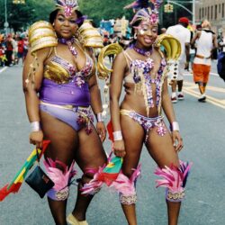 Two women in purple feathered carnival costumes