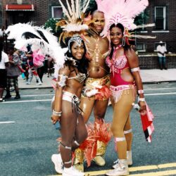 Three carnival dancers in vibrant feathered costumes