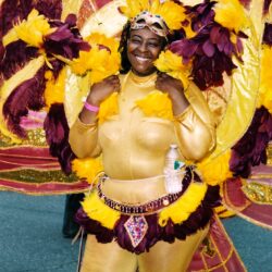 Smiling carnival performer in gold feathered costume