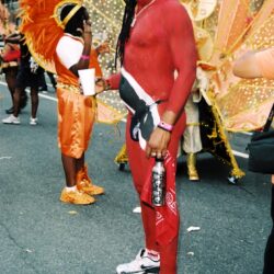 Person in red body paint at carnival parade