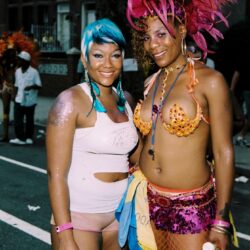Two women in colorful carnival costumes smiling