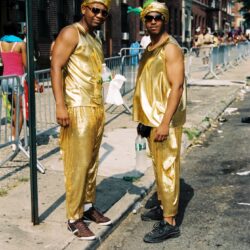 Two men in gold costumes at street festival