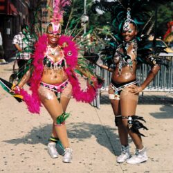 Two women in colorful feathered carnival costumes