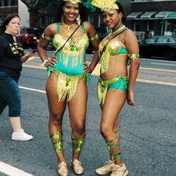 Two women in green and yellow carnival costumes