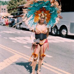 Parade participant in colorful costume and feathered headdress