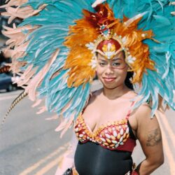 Smiling carnival dancer in vibrant feathered headdress