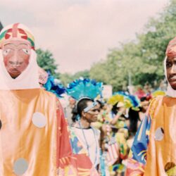 Two masked performers in colorful carnival costumes
