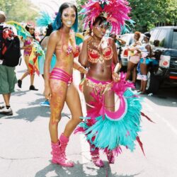 Two women in colorful carnival costumes walking