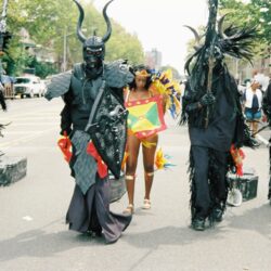 Caribbean carnival parade with horned costumes, dancer