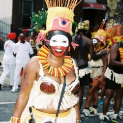 Smiling carnival performer in elaborate headdress and costume