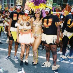 Carnival performers wearing colorful feathered costumes