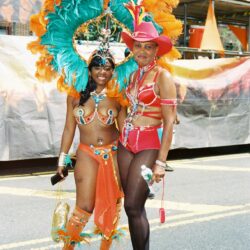 Two women in colorful carnival headdresses and costumes