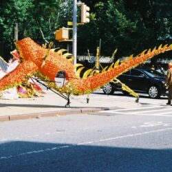 Orange dragon parade float on city street